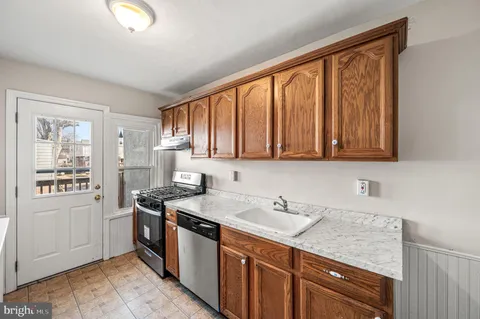 a kitchen with stainless steel appliances granite countertop a sink stove and cabinets