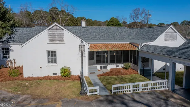 a view of a house with a yard and floor to ceiling window
