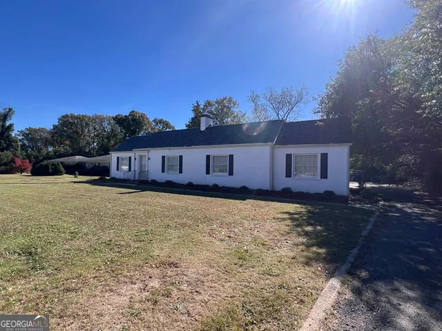 a view of a house with backyard and sitting area