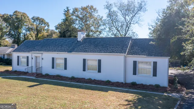 a view of a house with backyard and sitting area