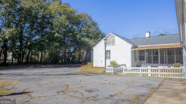 a front view of house with yard and trees in the background