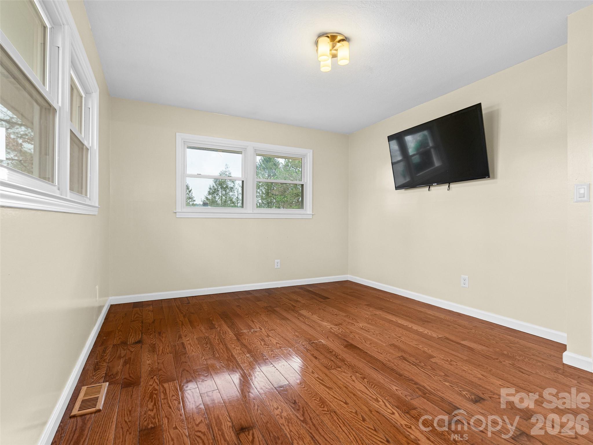 1034 South Orchard Road Flat Rock, NC 28731 - Photo 15 of 30 an empty room with wooden floor and windows