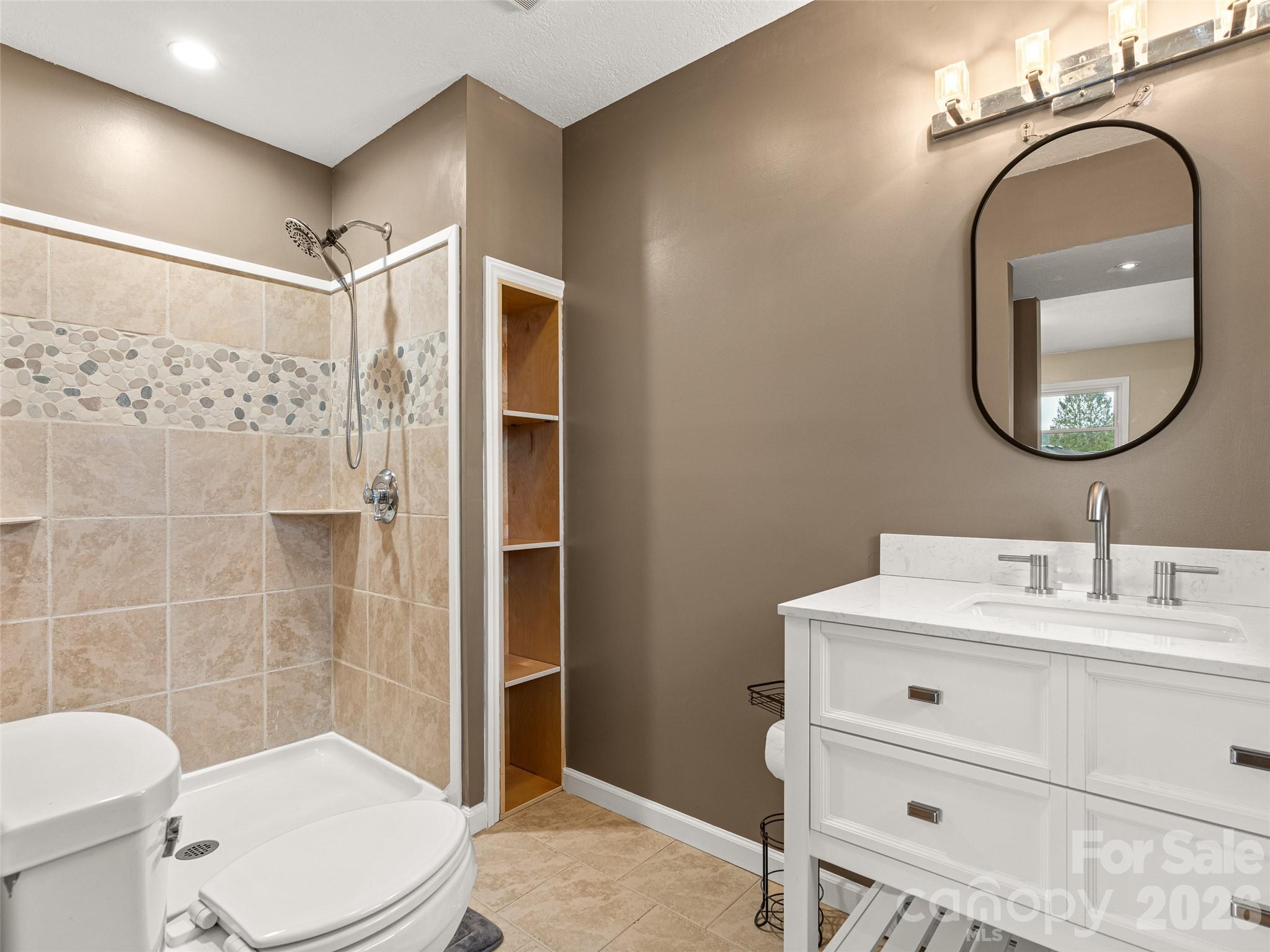 1034 South Orchard Road Flat Rock, NC 28731 - Photo 17 of 30 a bathroom with a toilet a sink and shower