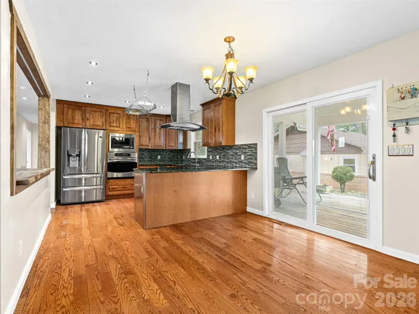 a large kitchen with stainless steel appliances kitchen island granite countertop a large counter top and outdoor space