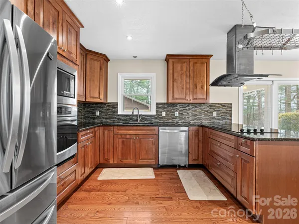 a kitchen with stainless steel appliances granite countertop a stove a sink and a microwave