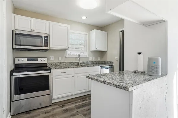 a kitchen with stainless steel appliances granite countertop a sink stove and microwave