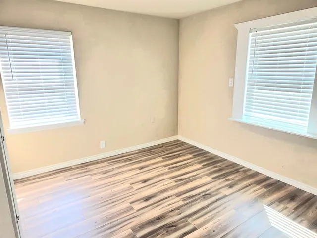 a view of a room with wooden floor and a window