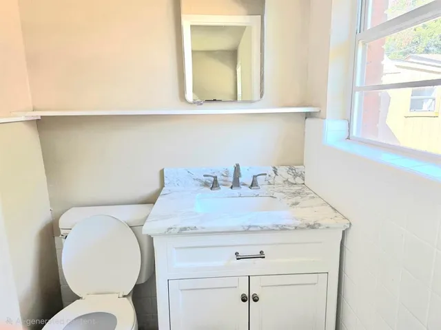 a bathroom with a toilet sink and mirror
