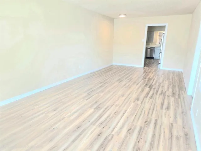 a view of a room with wooden floor and a ceiling fan