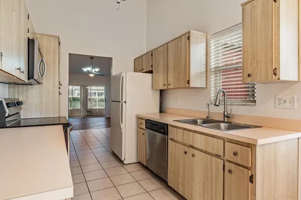 a kitchen with a sink a refrigerator and cabinets
