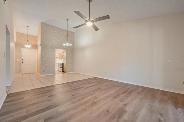 a view of a room with wooden floor and a ceiling fan