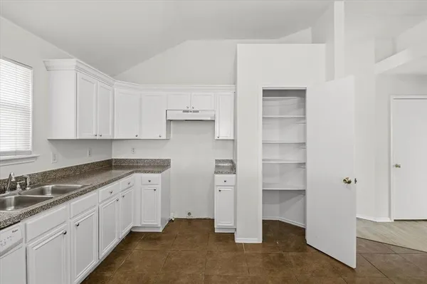 a kitchen with cabinets and window