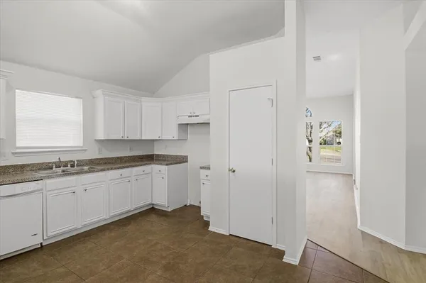 a room with granite countertop cabinets and sink