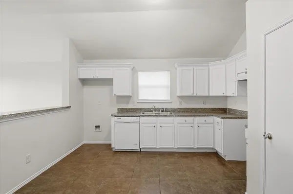 a kitchen with granite countertop white cabinets and white appliances