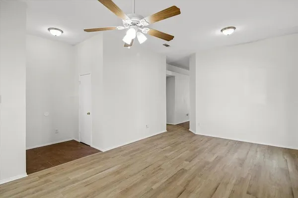 a view of an empty room with wooden floor