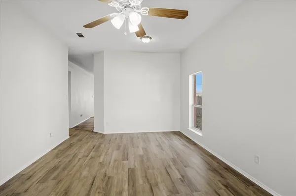 a view of wooden floor and a chandelier fan in a room