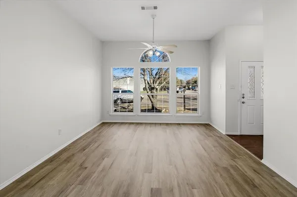 a view of a room with wooden floor chandelier and windows