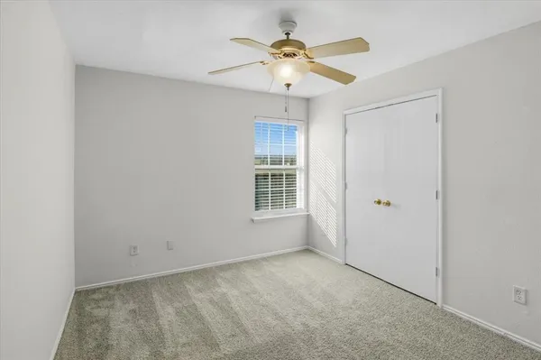 a view of an empty room with a ceiling fan