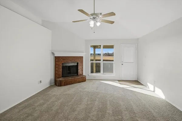 an empty room with fireplace and windows