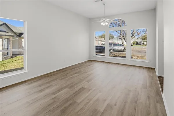 a view of a room with wooden floor chandelier and windows