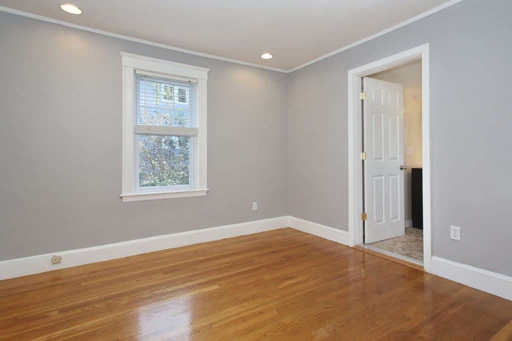 199-201 Langley Road, Unit 201 Newton, MA 02459 - Photo 4 of 5 an empty room with wooden floor and windows