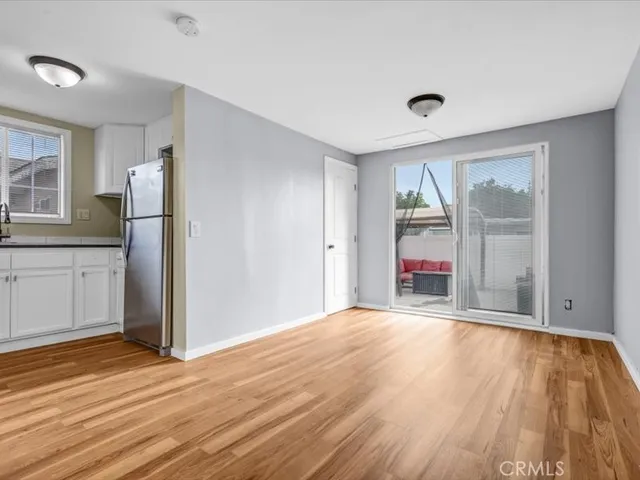 a view of an empty room with window and wooden floor