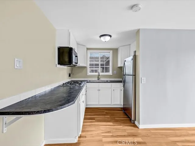 a kitchen with stainless steel appliances granite countertop a refrigerator stove top oven and sink