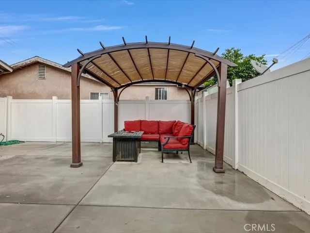 a view of a patio with table and chairs under an umbrella