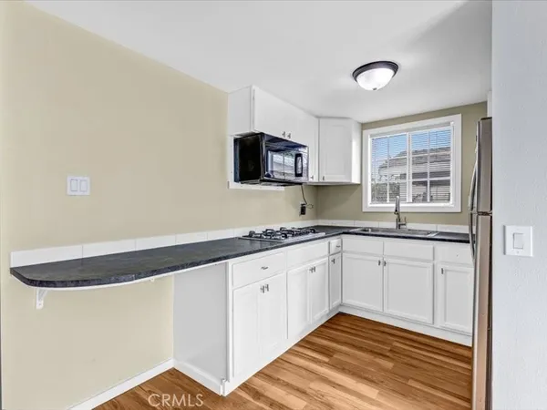 a kitchen with granite countertop white cabinets and a sink