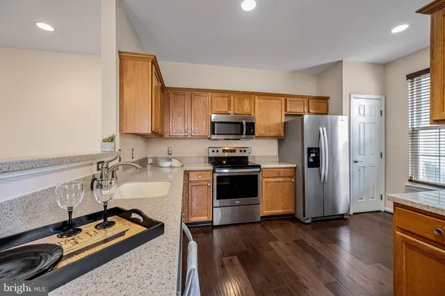 a kitchen with a refrigerator stove and wooden floor
