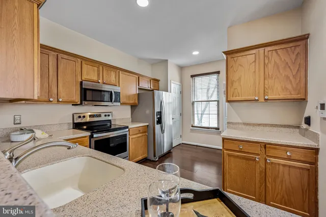 a kitchen with stainless steel appliances granite countertop a sink refrigerator stove microwave and cabinets