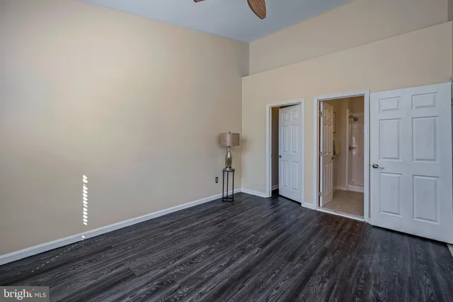 a view of an empty room with wooden floor and closet