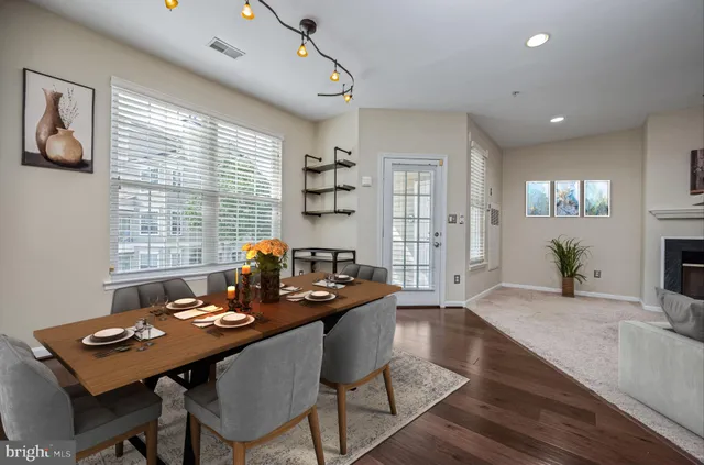 a view of a dining room and livingroom with furniture wooden floor and a rug