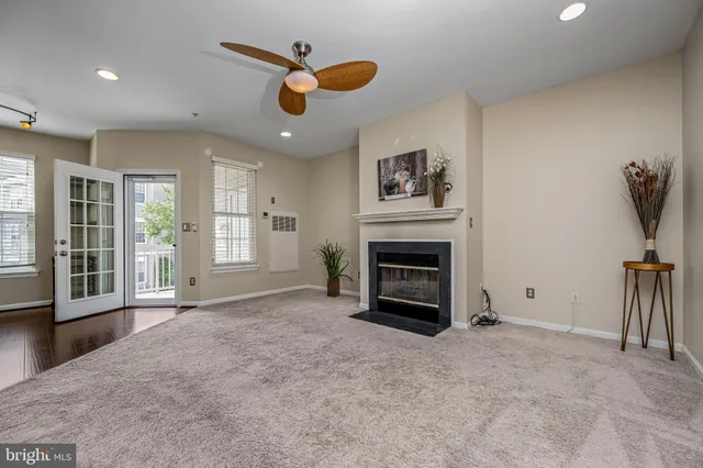 an empty room with windows and fireplace