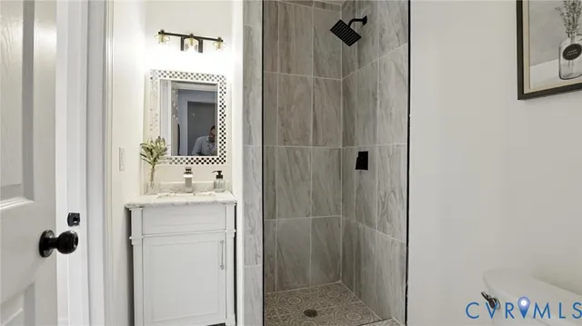 a bathroom with a shower a mirror and a sink