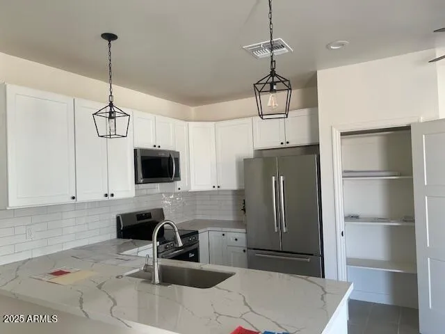 a kitchen with stainless steel appliances granite countertop a refrigerator a sink and a stove