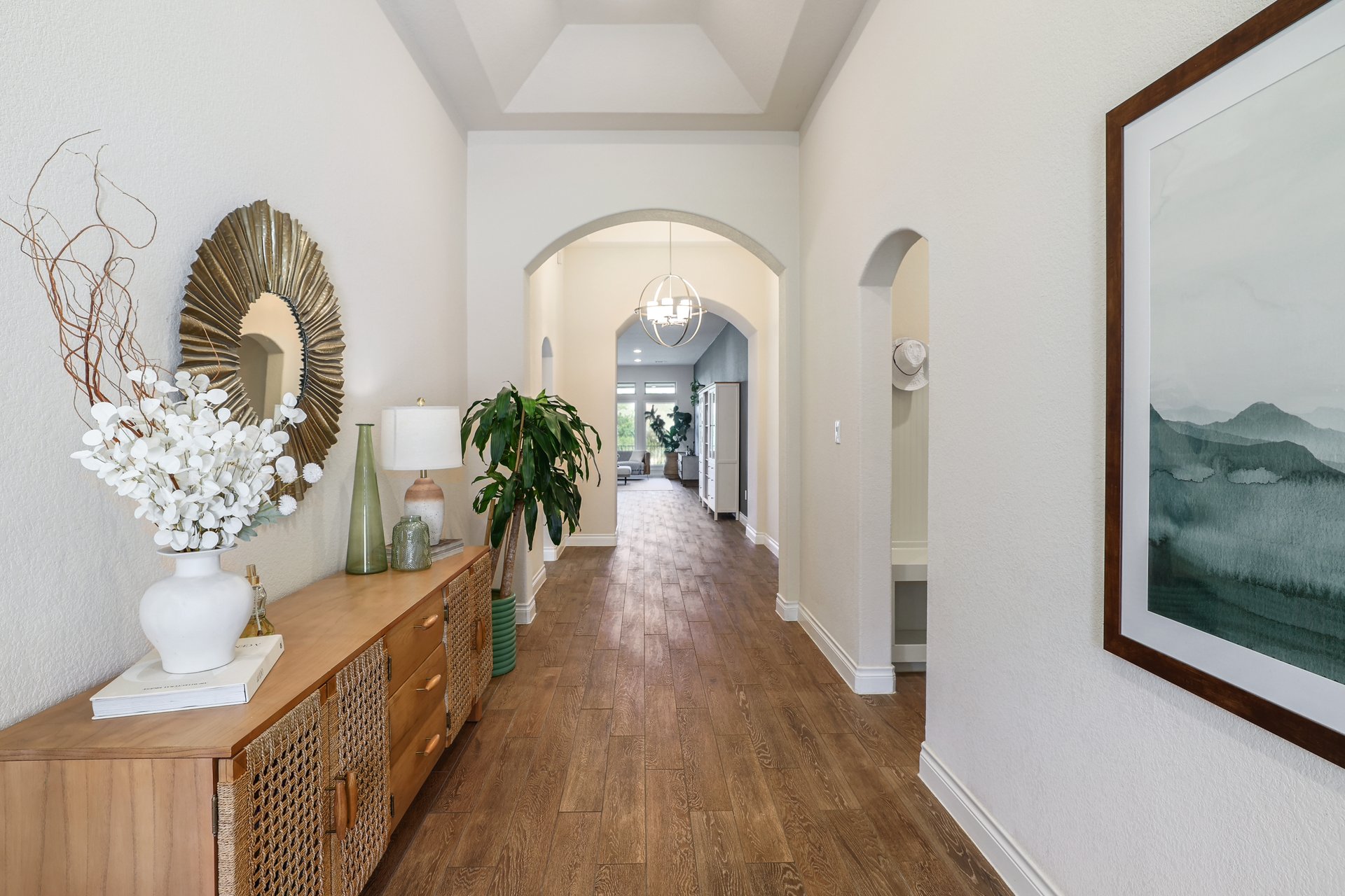 173 Santa Maria Street Georgetown, TX 78628 - Photo 11 of 39 Hallway featuring wood-finish flooring, vaulted ceiling detail, and arched doorways