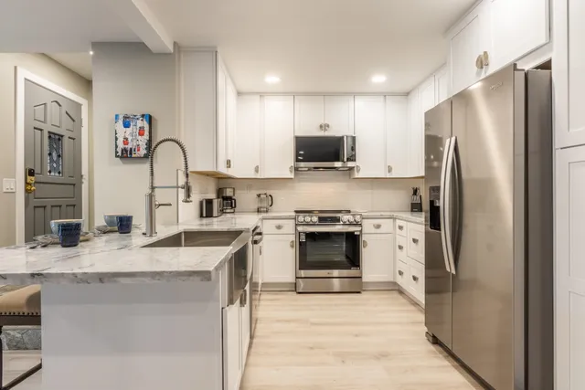 a kitchen with stainless steel appliances granite countertop a refrigerator sink and stove