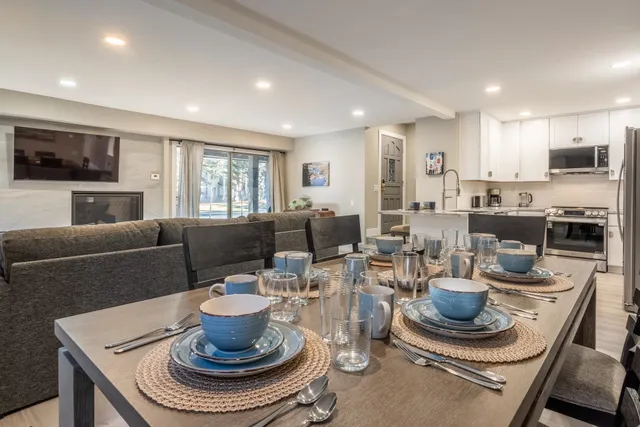 a living room with furniture a flat screen tv and kitchen view
