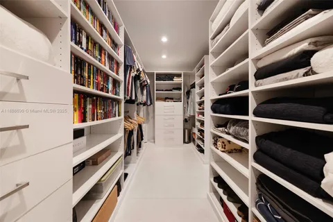 a view of walk in closet with clothes and shoes