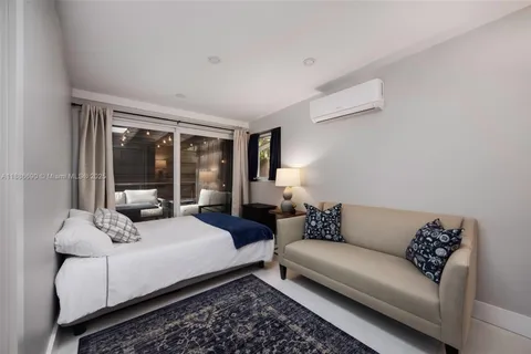 a bedroom with bed couch and window