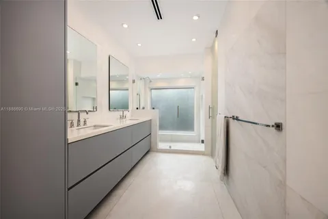a bathroom with a double vanity sink mirror and shower