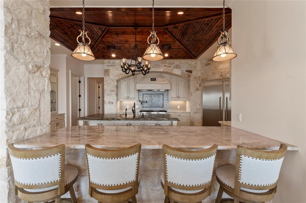 204 Pinnacle Club Place Mabank, TX 75156 - Photo 11 of 40 Bar seating connects the kitchen with the dining and living areas.