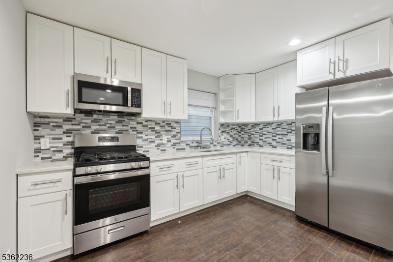 253 North 4th Street Paterson, NJ 07522 - Photo 1 of 15 a kitchen with granite countertop white cabinets and stainless steel appliances