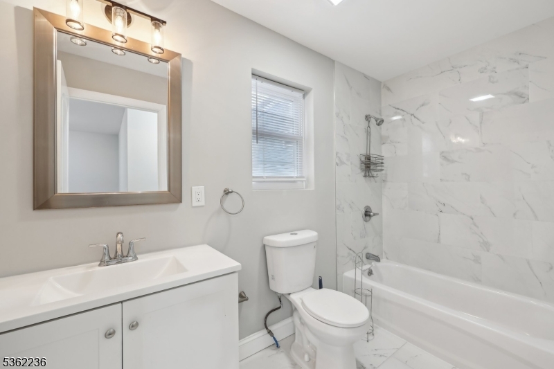 253 North 4th Street Paterson, NJ 07522 - Photo 13 of 15 a bathroom with a granite countertop sink a toilet and a bathtub