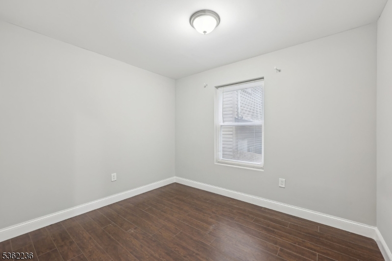253 North 4th Street Paterson, NJ 07522 - Photo 7 of 15 an empty room with wooden floor and windows
