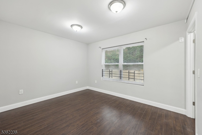 253 North 4th Street Paterson, NJ 07522 - Photo 10 of 15 an empty room with wooden floor and windows