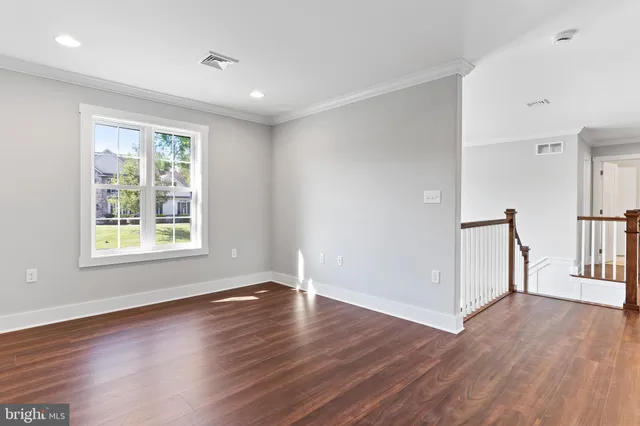 a view of an empty room and chandelier fan