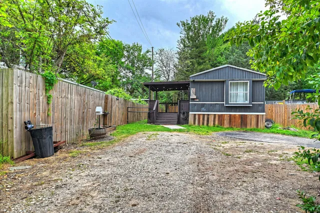 a view of a house with a yard and large tree