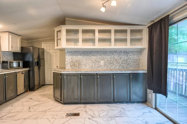 a kitchen with stainless steel appliances granite countertop a refrigerator and a sink